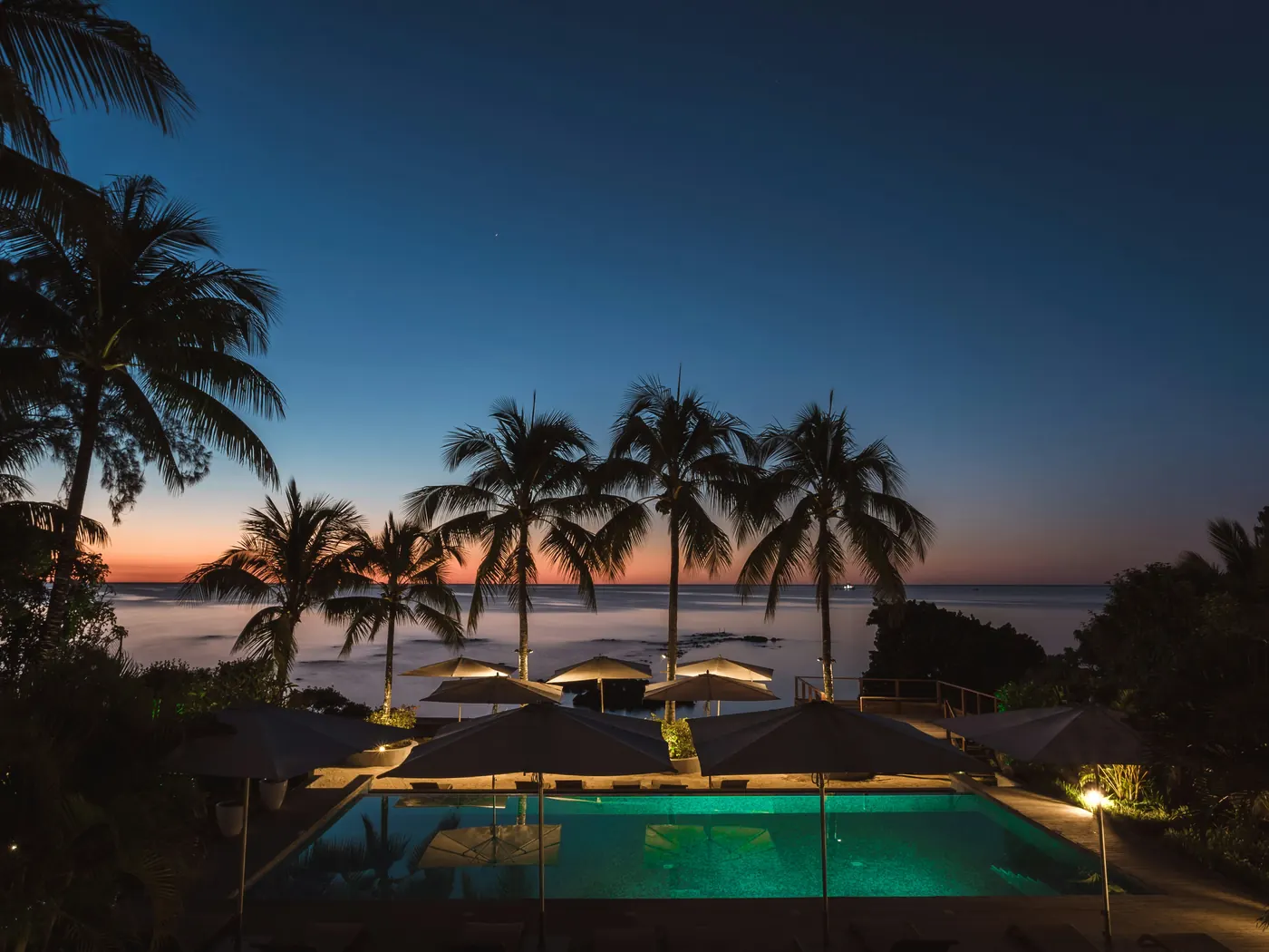 Resort pool and palms at dusk on the Ghanaian coast